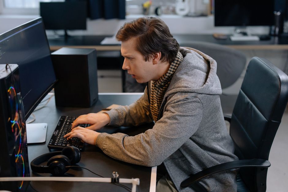 Focused male programmer working at office desk, coding efficiently.